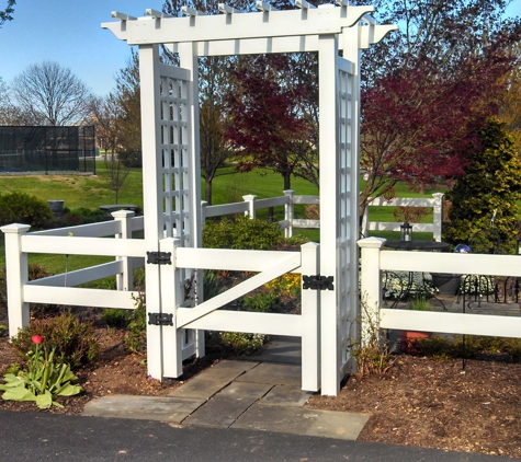 Pro Max Fence Systems - Reading, PA. Custom vinyl arbor with ranch style fencing compliments this lovely garden.  