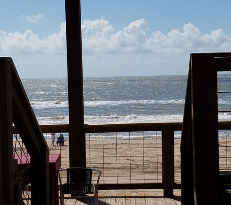 Ocean Village Hotel - Surfside Beach, TX. deck on the back by restaurant with a deck above and a shaded deck below. Shower to rinse off before going to your room.