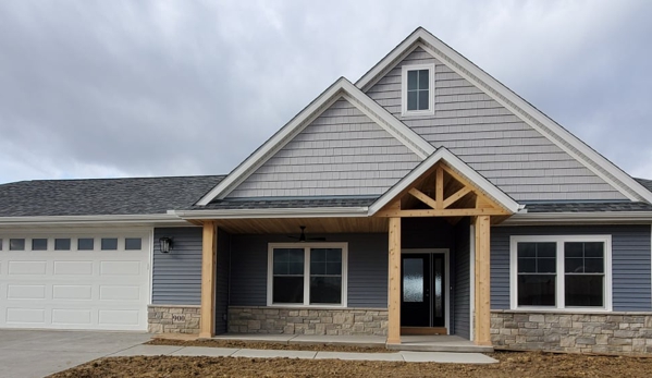 Hazelwood Homes. Ranch home with 3 car attached garage, stone with gray siding and cedar accents.