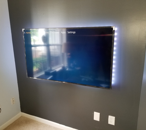 Buzz Electric - Dearborn, MI. Flat screen tv mounted to wall with outlet behind it and led backlit lights