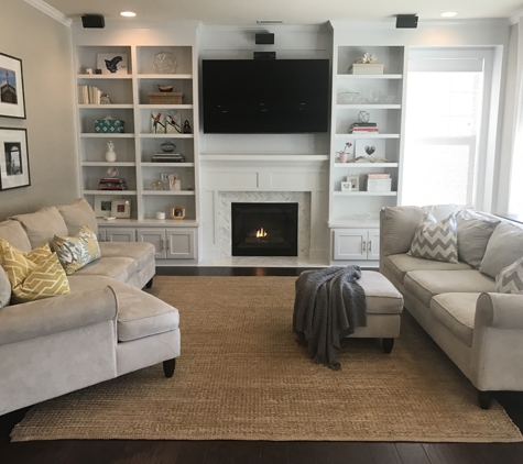 Woodmaster Woodworks - Wake Forest, NC. Paint grade built-ins with white cabinets, adjustable shelves and a window seat with storage to the side.