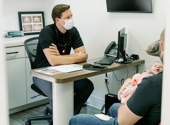 Smile Team Pediatric Dentistry - Fort Worth, TX. Medicaid Pediatric dentist Justin Warcup in  the consultaion room at Smile Team Pediatric Dentistry office