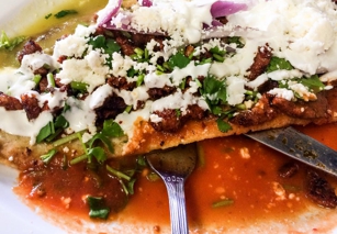 Huarache masa flatbread with toppings at El Huarache Azteca in Los Angeles, CA