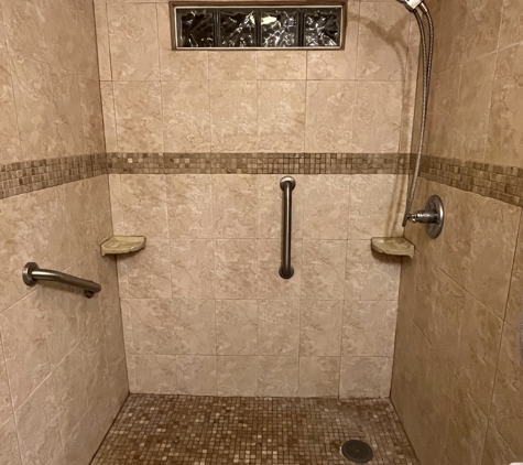 iFixit Handyman Services LLC - Panama City Beach, FL. Tiled shower with tumbled marble floor and wall accent.