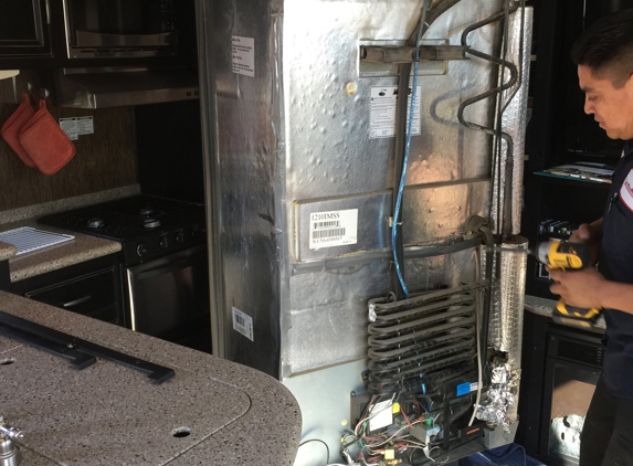 4 Points RV Service LLC - Mesa, AZ. Juan replacing the cooling unit on the back of the refrigerator