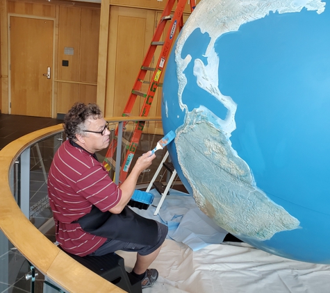 Universal Fine Art - Estill, SC. Art Conservator, Dimitri Nedelcu repainting the globe.