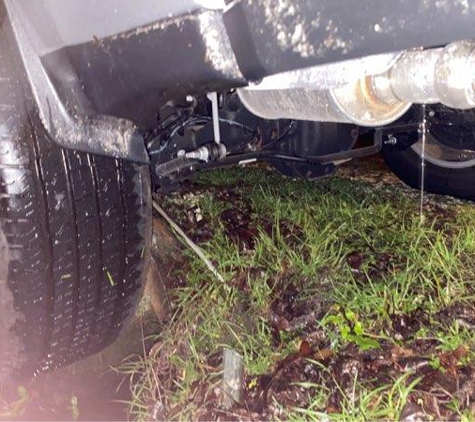 Mike's Auto Towing - Spring Hill, FL. Wheel hanging over the ditch, stuck on the culvert