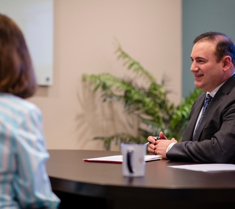 Outlook Wealth Advisors - College Station, TX. Neuenschwander, CPA, CFP® meeting with clients to review their wealth management plan.