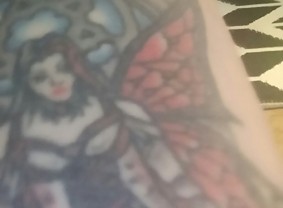 T's Tattoo Inc - Hudson, MA. Sorry it's light and the pic has more detail. He turned a fairy into a cemmetary watcher. Thanks T got a lot of compliments.