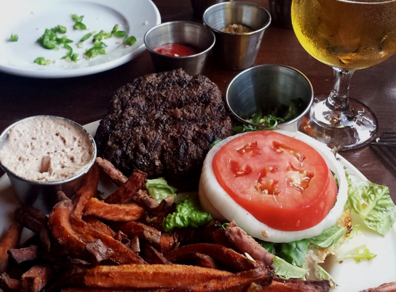 5 Seasons Brewing - Alpharetta, GA. Juicy, perfectly cooked medium grass-fed beef burger, fresh vegetables, and rustic sweet potato fries with various condiments and cider beer